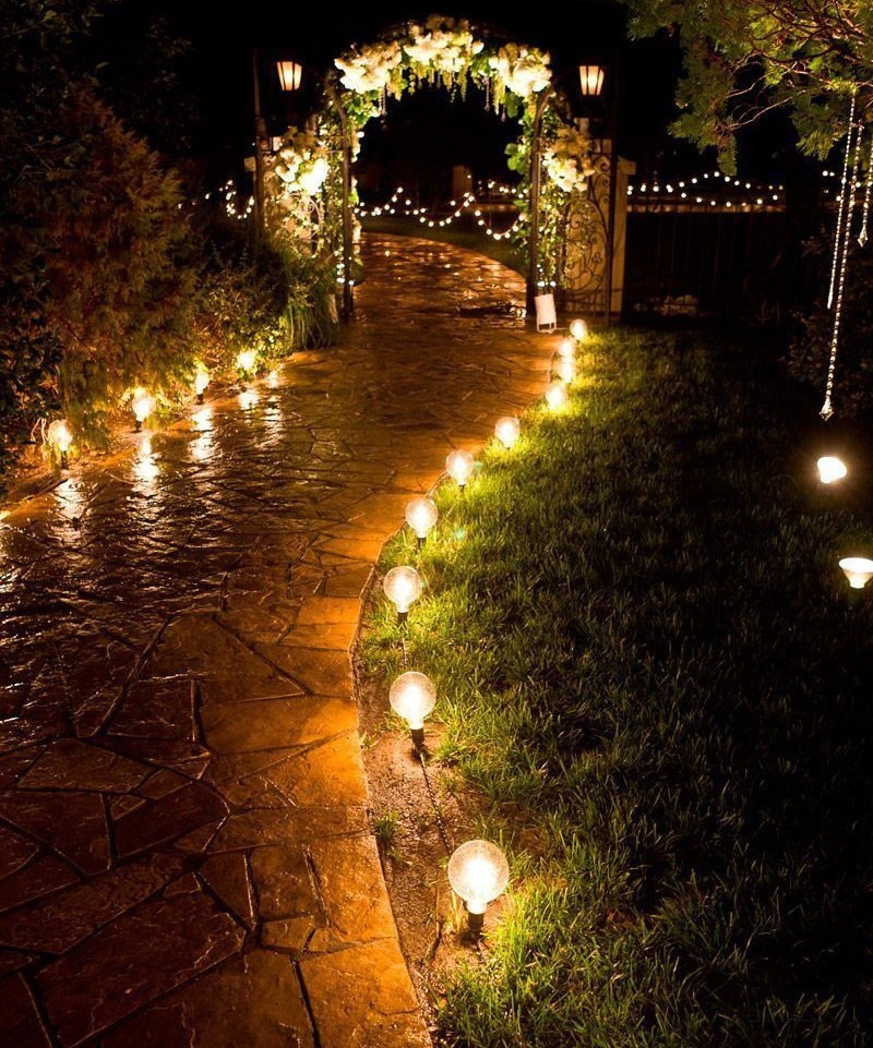 Цепочка светодиодных фонариков вдоль тропинки в саду