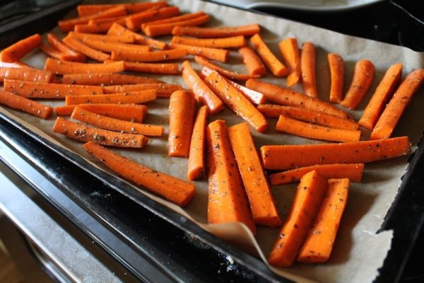 усочки моркови на противне с пекарской бумагой