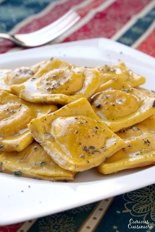 Pumpkin infused homemade pasta makes the perfect vessel for a creamy tarragon cheese filling in this fall Pumpkin Ravioli Recipe.  