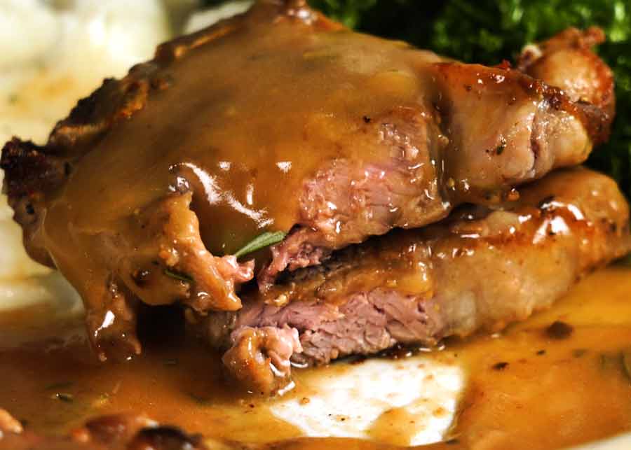Showing the inside of perfectly cooked lamb chops with rosemary gravy