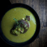 curried split pea soup in a bowl with ham hock