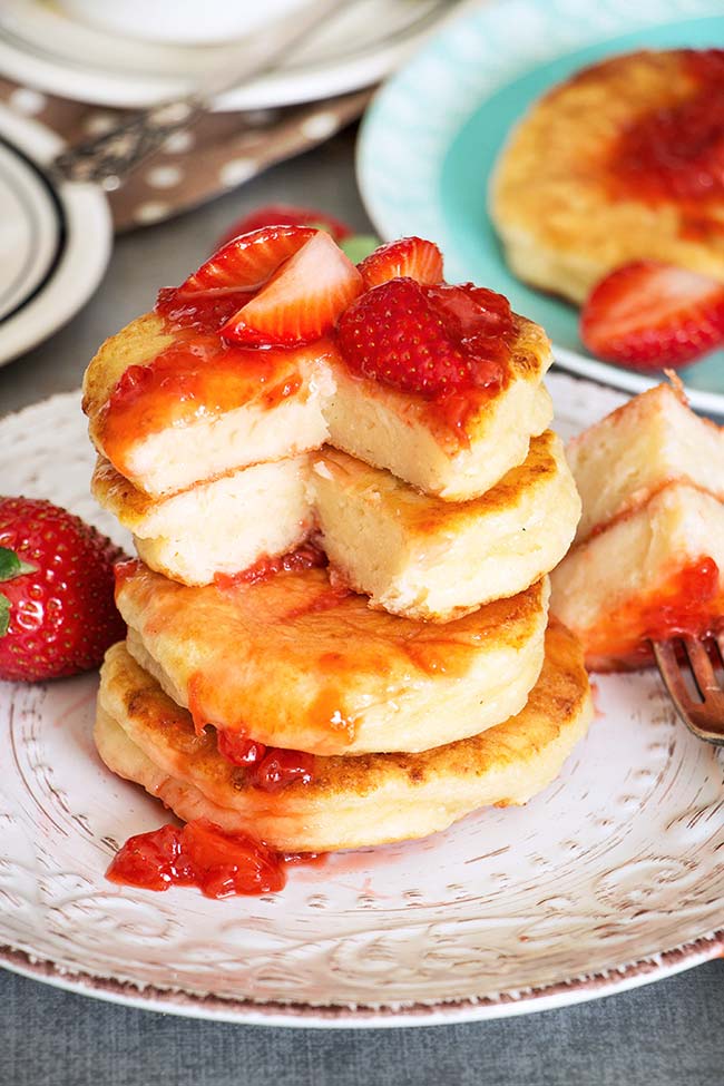 These famous Russian sweet cheese pancakes (Syrniki) are made with cottage cheese and served with a gorgeous fresh strawberry sauce. SO GOOD! 